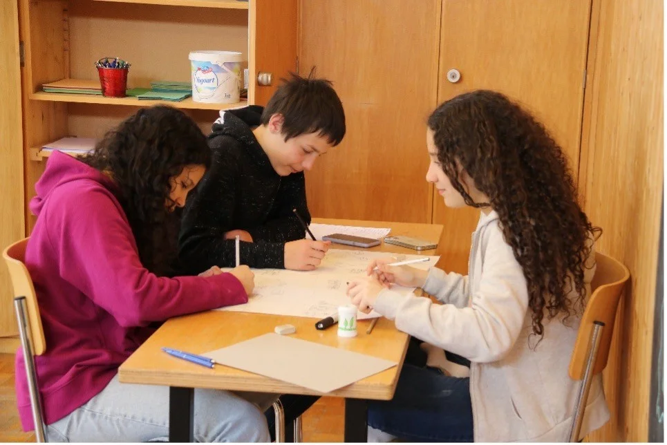 Eine Gruppe von Schüler*innen arbeiten zusammen an einem Projekt