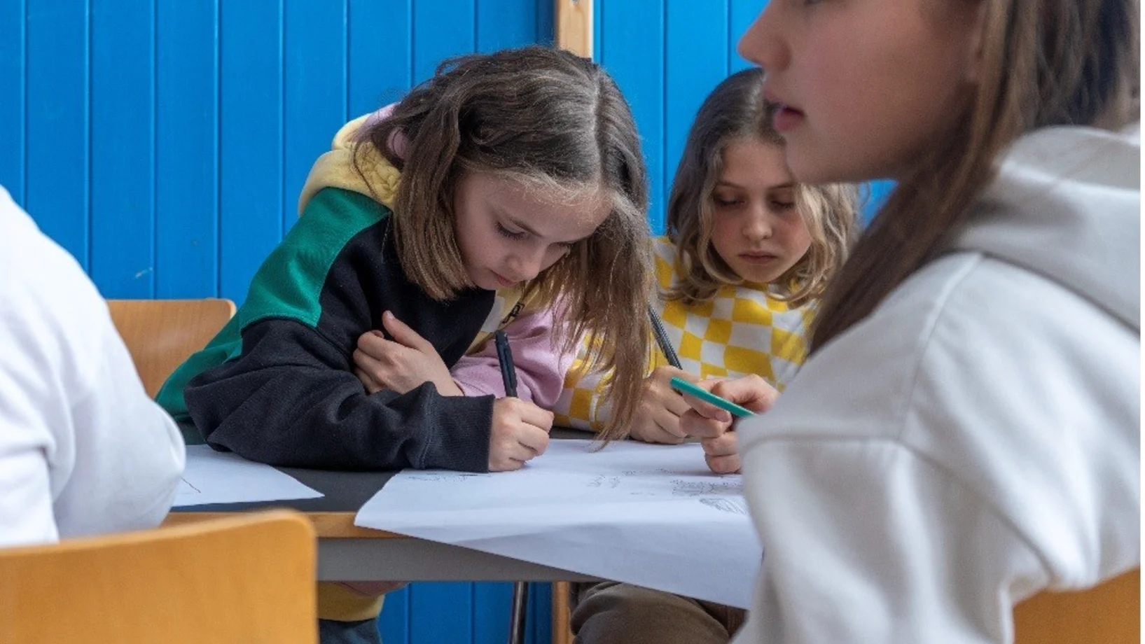Kinder arbeiten gemeinsam an einem Plakat und halten Ideen fest. Praxisbeispiel für Kinderrechte, Partizipation, Mitbestimmung und gemeinsames Lernen.